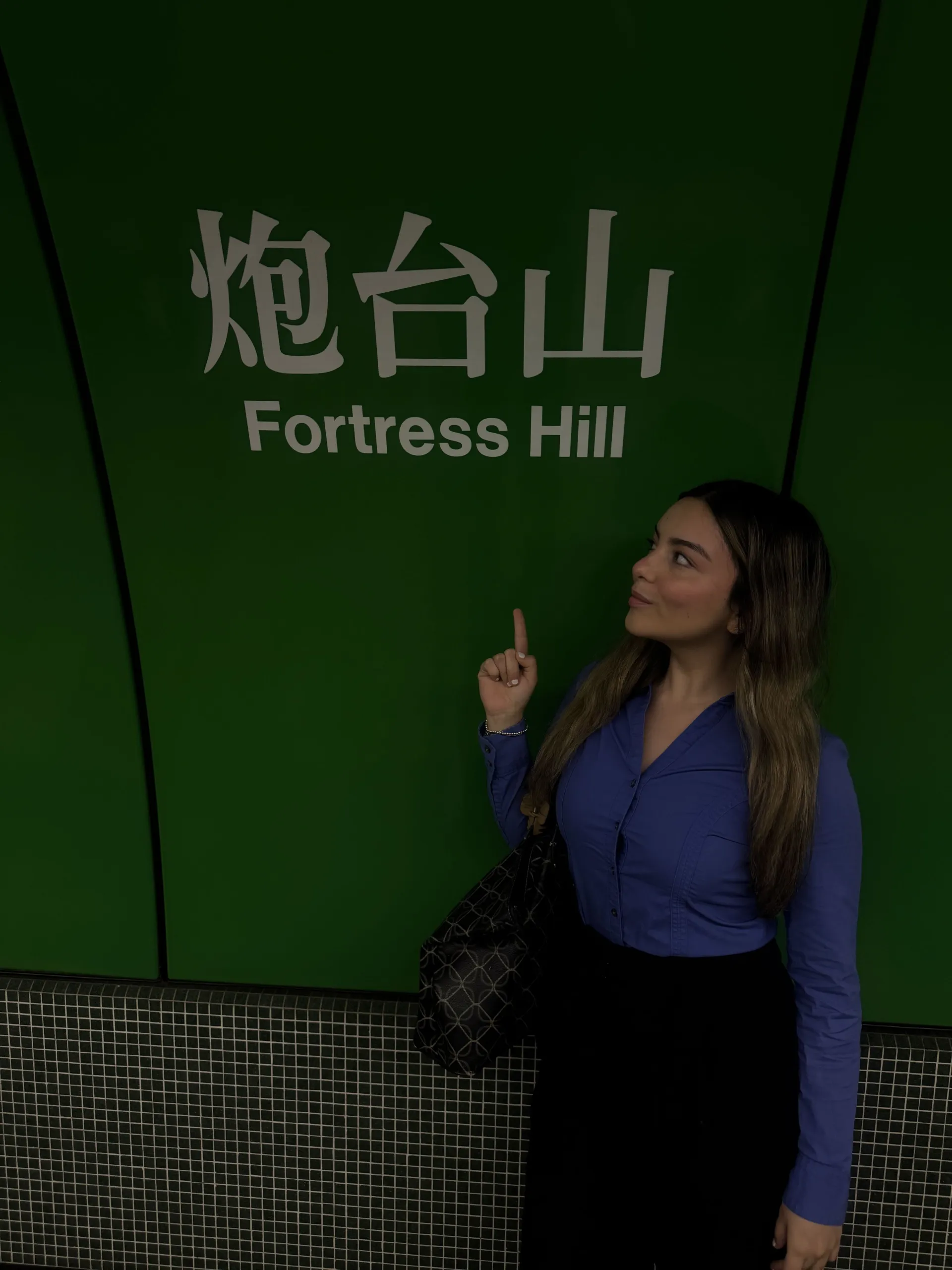 The signature green wall and bilingual signage at the Fortress Hill MTR Station on Hong Kong Island.. Photo credit: Isabella Lopez